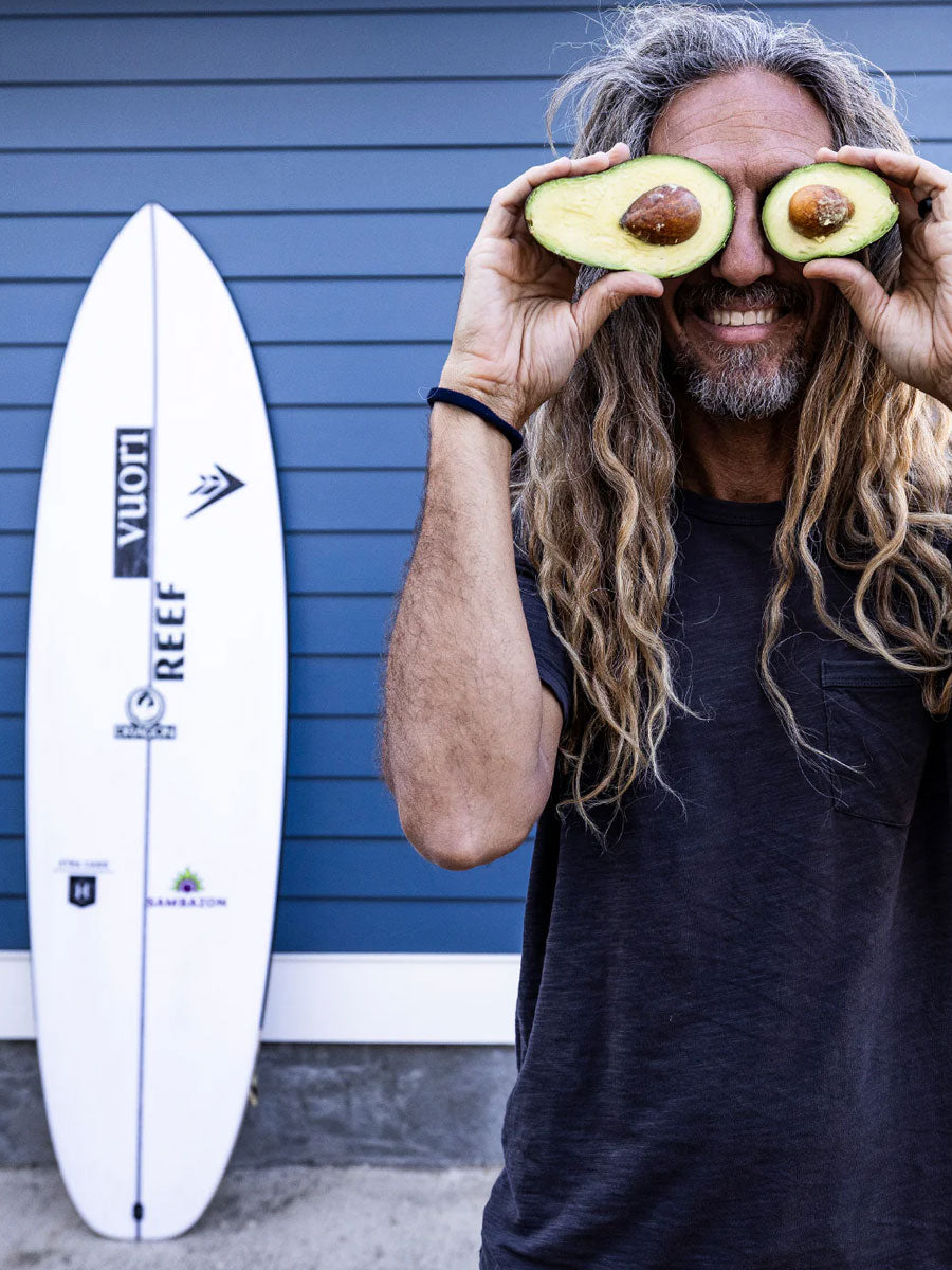 Rob Machado posing with avocados beside the Firewire Xtra Cado surfboard