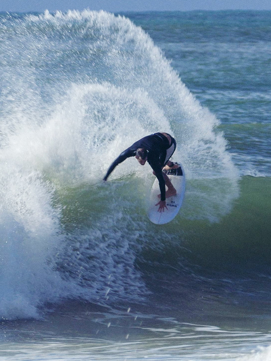 Surfer carving a turn on the HIBT 3+3 Thunderbolt surfboard