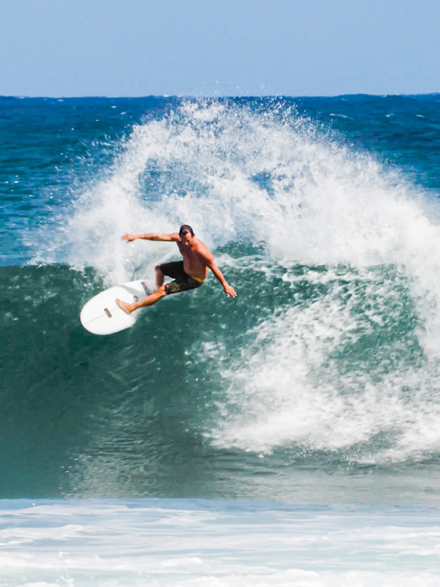Surfer punting an air off the lip on the Pyzel Score Lord surfboard