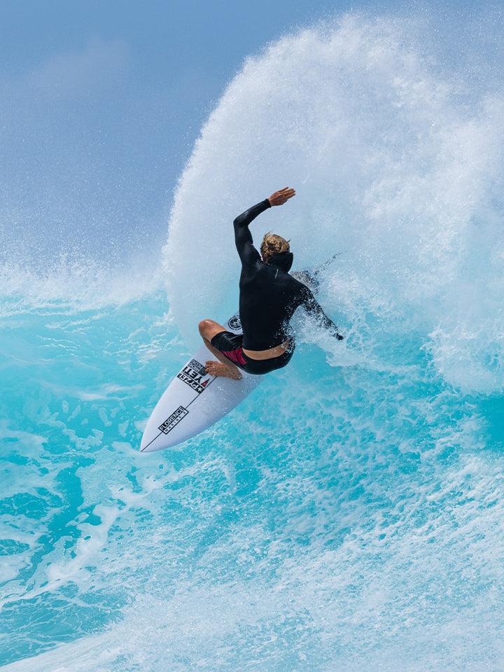 Surfer riding a big wave on the Pyzel Ghost surfboard