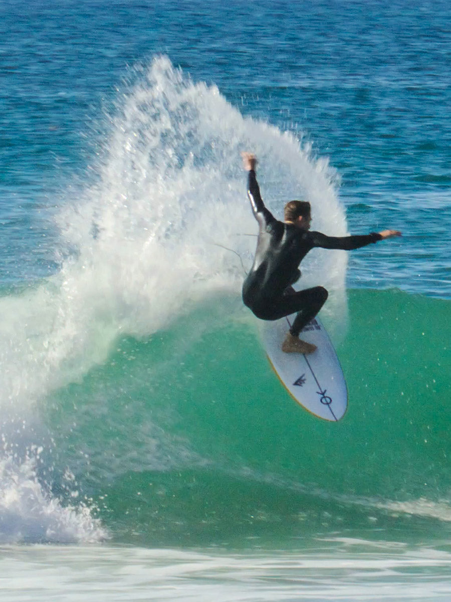 Surfer performing an aerial turn on the Firewire Spun Honey surfboard